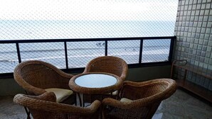 Ein Balkon mit Korbmöbeln und Meerblick.