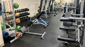 A gym with various exercise equipment, including dumbbells, medicine balls, and weight machines. - VA Beach Retreat! Quiet and perfect for families! Come enjoy Sandbridge Beach! (Virginia Beach)