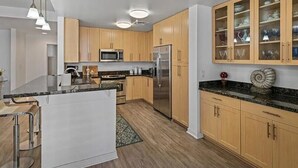A modern kitchen with wooden cabinets, stainless steel appliances, and a central island. - VA Beach Retreat! Quiet and perfect for families! Come enjoy Sandbridge Beach! (Virginia Beach)