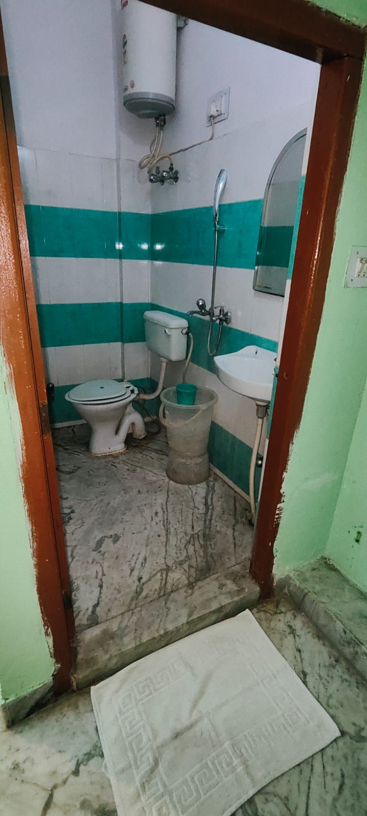 A small, narrow bathroom with a toilet, bidet, and sink.