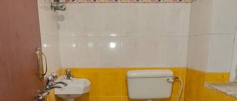 A small bathroom with a toilet, sink, and a water heater mounted on the wall.