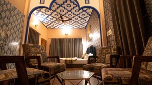 A room with patterned sofas, a glass coffee table, and a decorative ceiling. - Haveli Banquet & Resort (Ajmer)