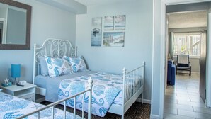 A bedroom with a bed, bedside table, and a mirror.