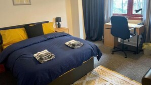 Een hotelkamer met een bed, een bureau en een stoel.