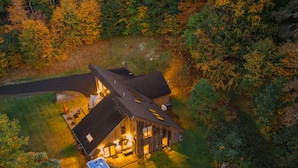 A lodge with a large deck, outdoor seating, and a fire pit.