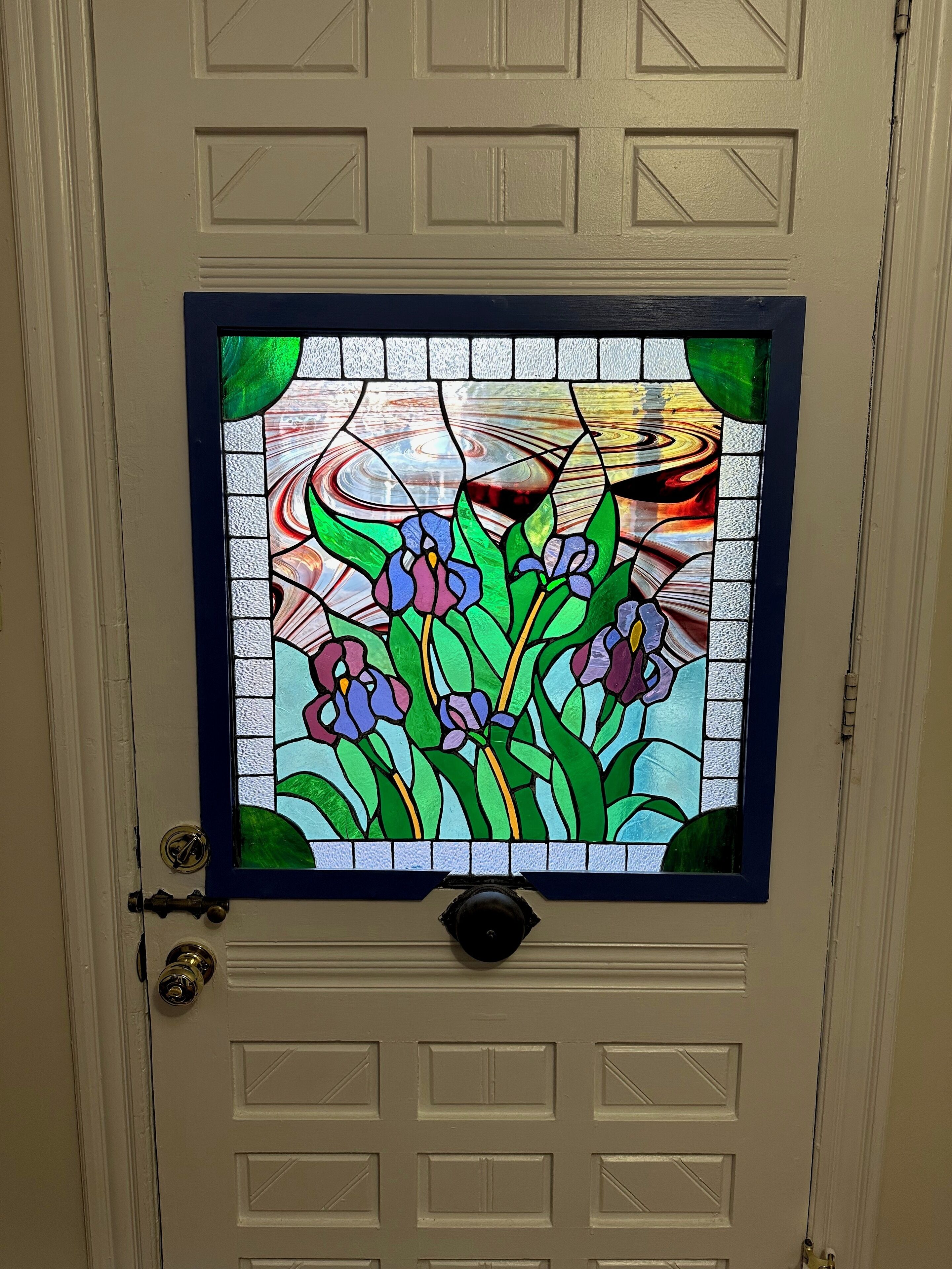 A door with a stained glass window featuring floral patterns.