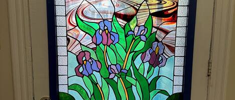 A door with a stained glass window featuring floral patterns.