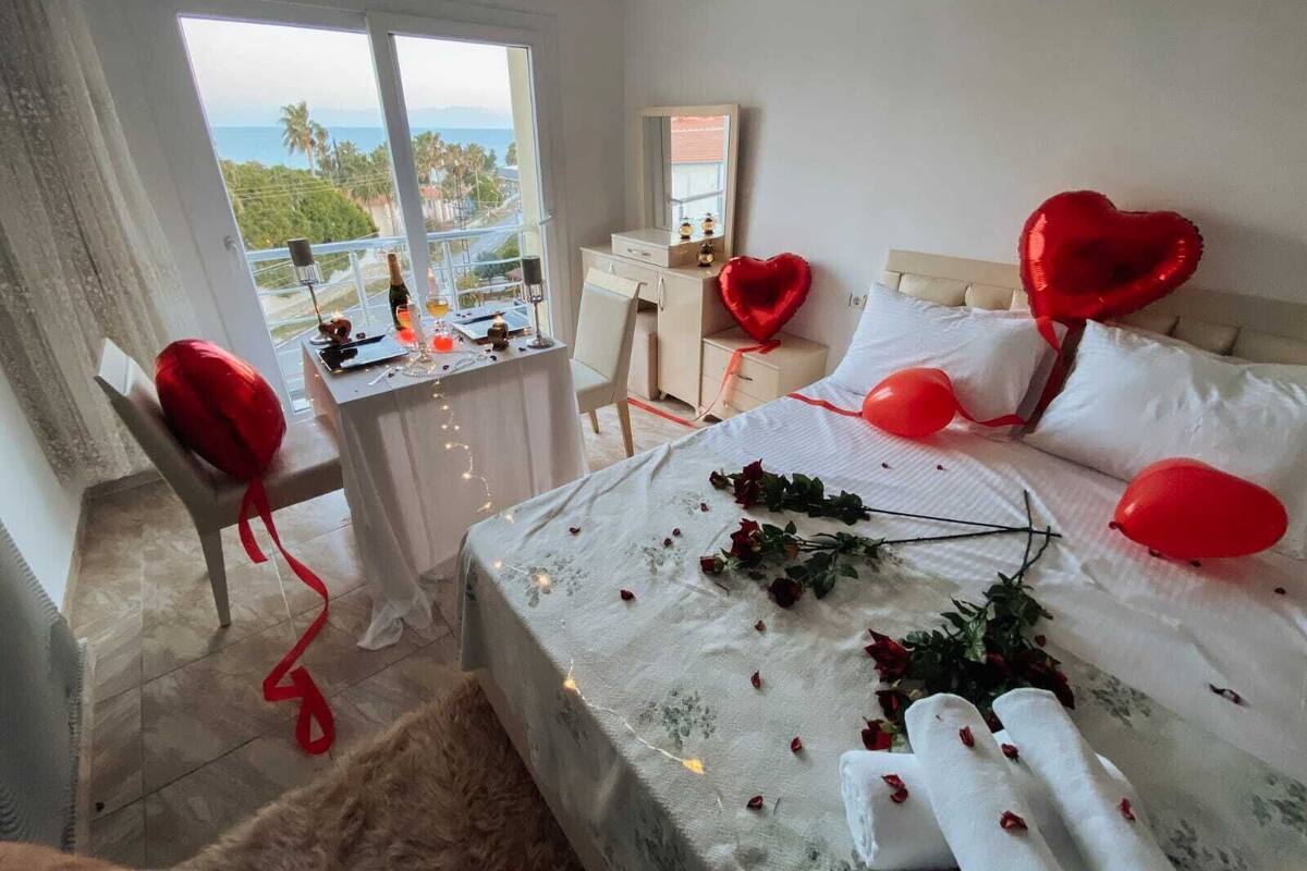 A hotel room with a bed, a desk, and a view of the ocean.