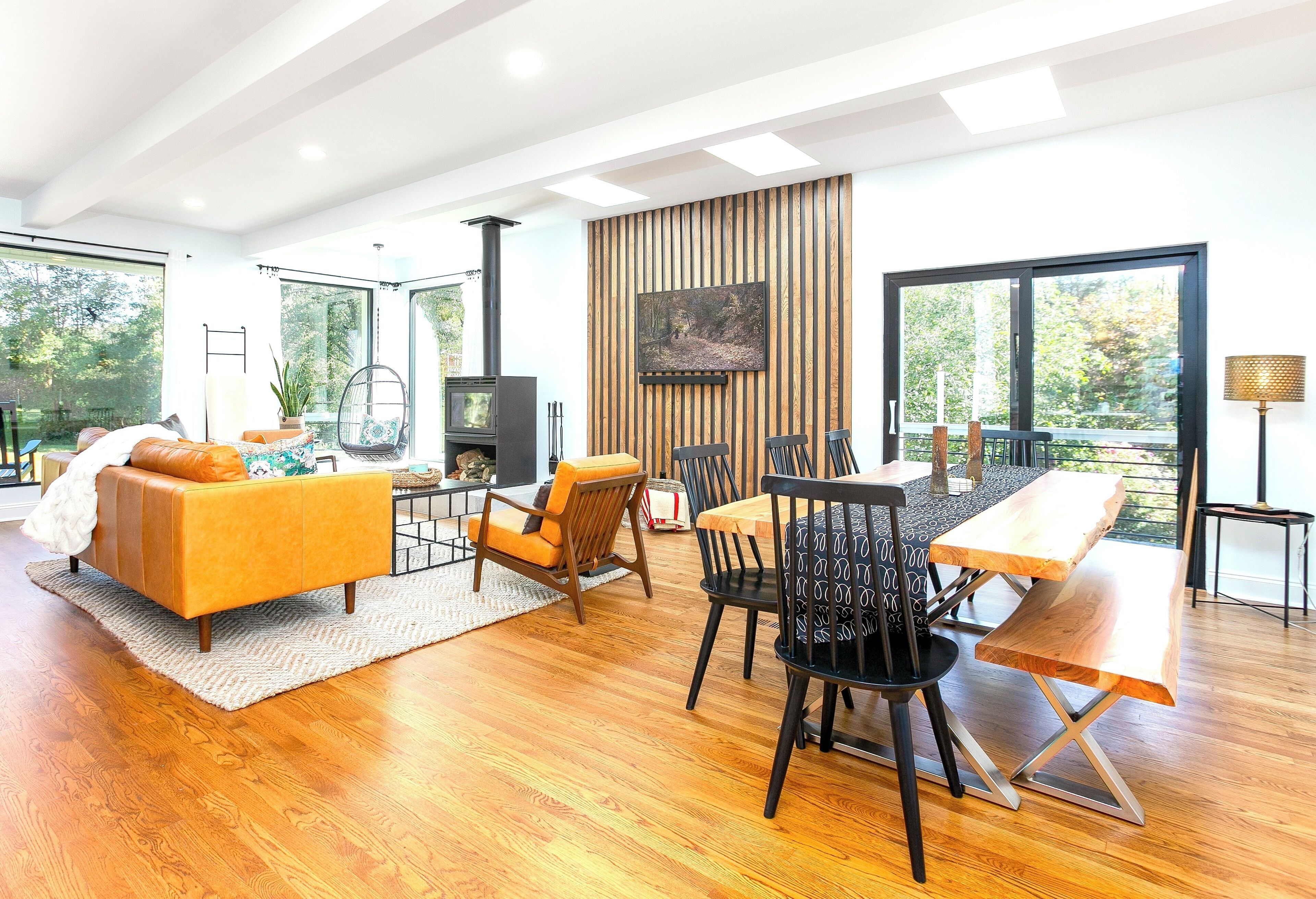 Sunlit retreat with cozy chair, luxe leather seating, and warm woodstove vibes.