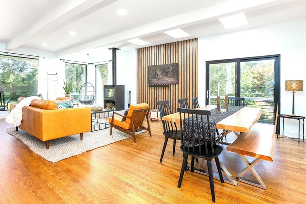 Sunlit retreat with cozy chair, luxe leather seating, and warm woodstove vibes.