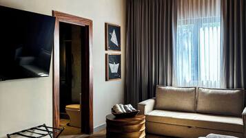 Habitación junior | Área de sala de estar | Smart TV de 75 pulgadas con canales por cable