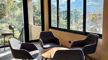 Un interior moderno con ventanas amplias, techo de madera y muebles contemporáneos.