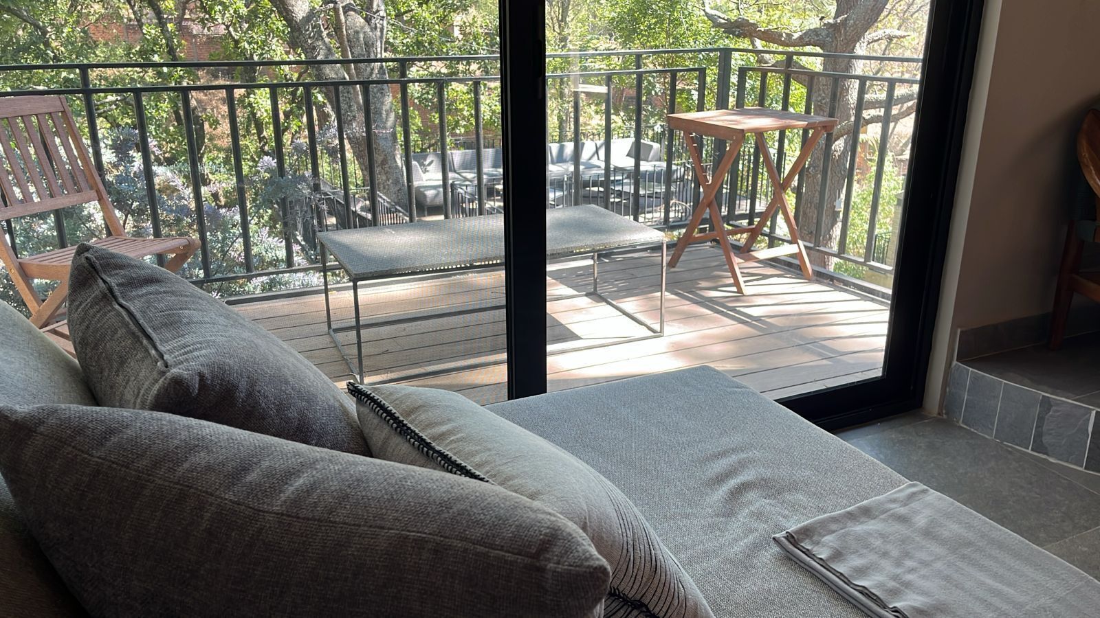A balcony with a sofa, a small table, and chairs.