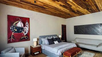 Un dormitorio moderno con techo de madera, una cama grande, un sofá y un cuadro en la pared.