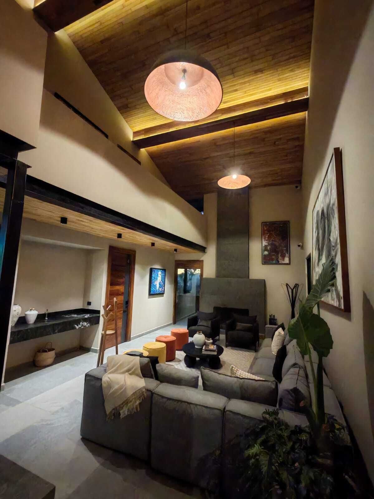 Een moderne woonkamer met een bank, salontafel en hanglampen.