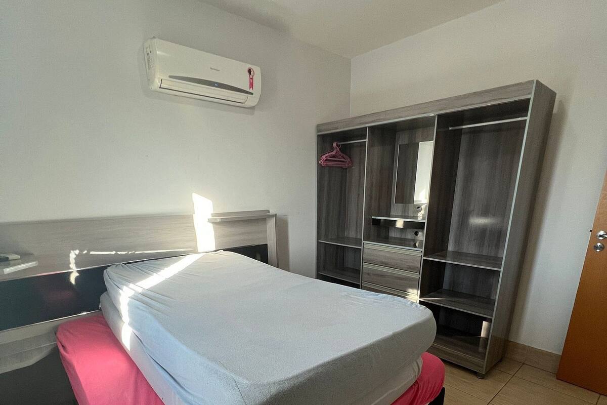 Une chambre d’hôtel équipée d’un lit, d’une armoire et d’un appareil de climatisation.