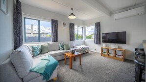 Ein Wohnzimmer mit Sofa, Couchtisch, Fernseher und einer Bar.