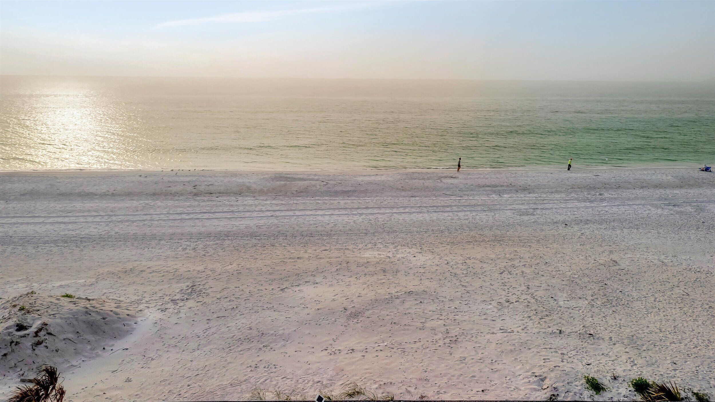 A beach with a sandy shore and calm water.