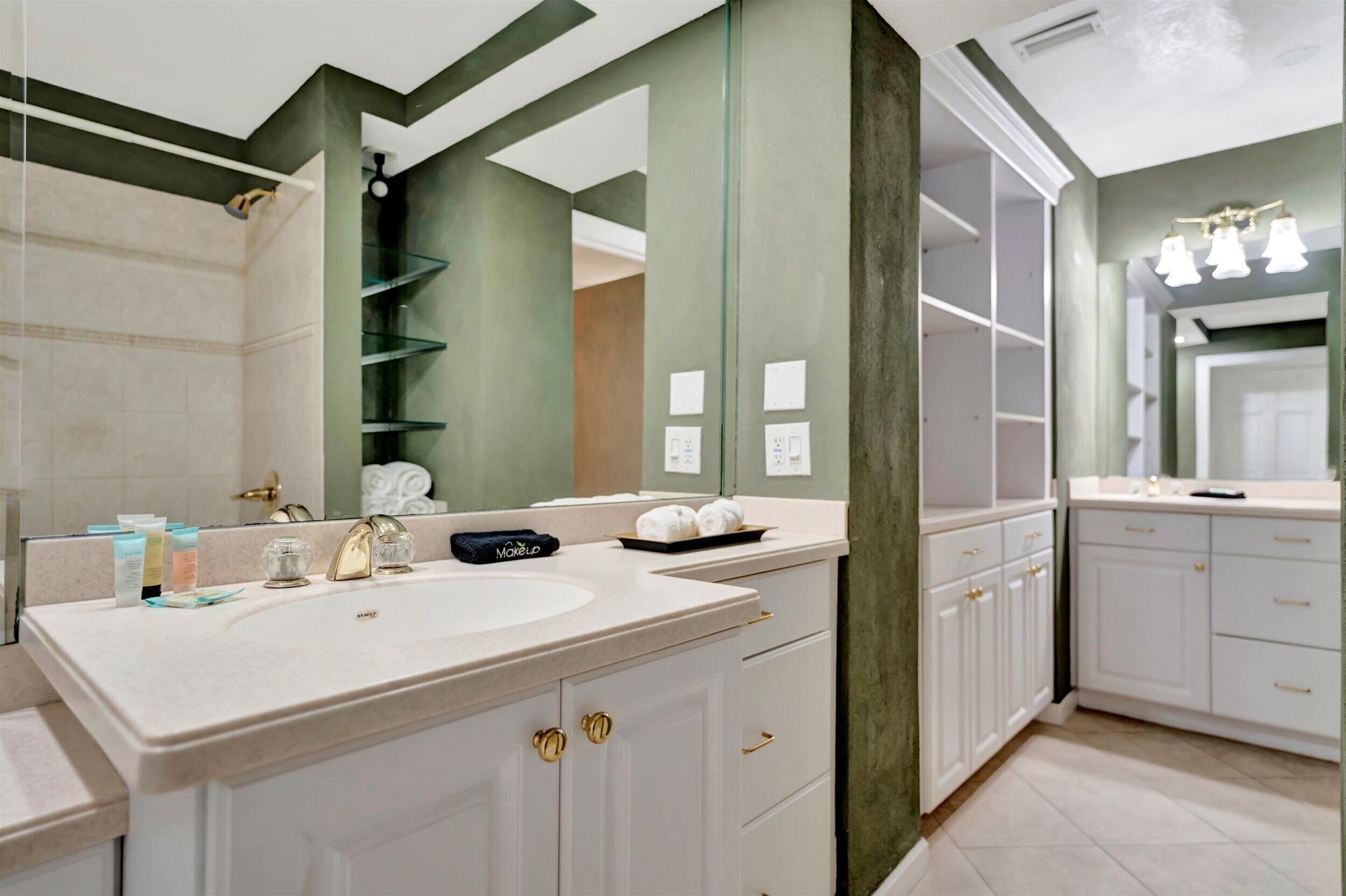 A modern bathroom with a double sink, a large mirror, and a vanity with storage cabinets.