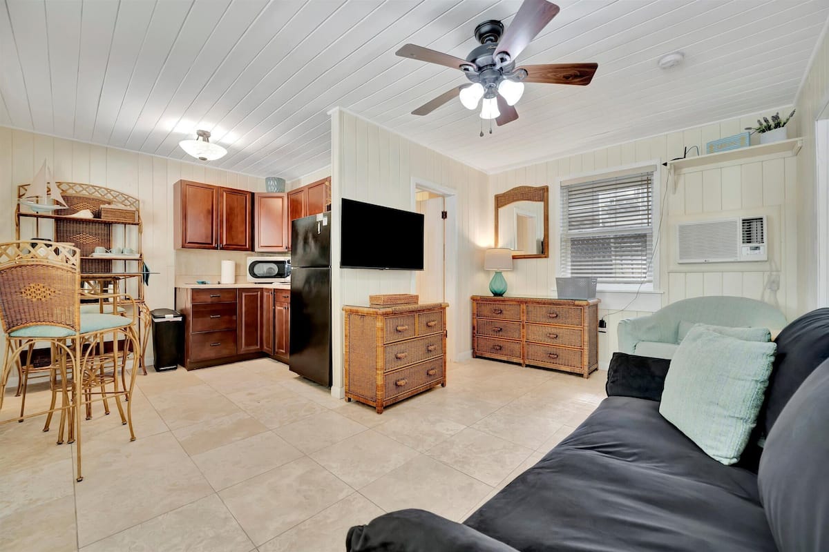 Un espacio habitable compacto con kitchenette, comedor y zona de estar.