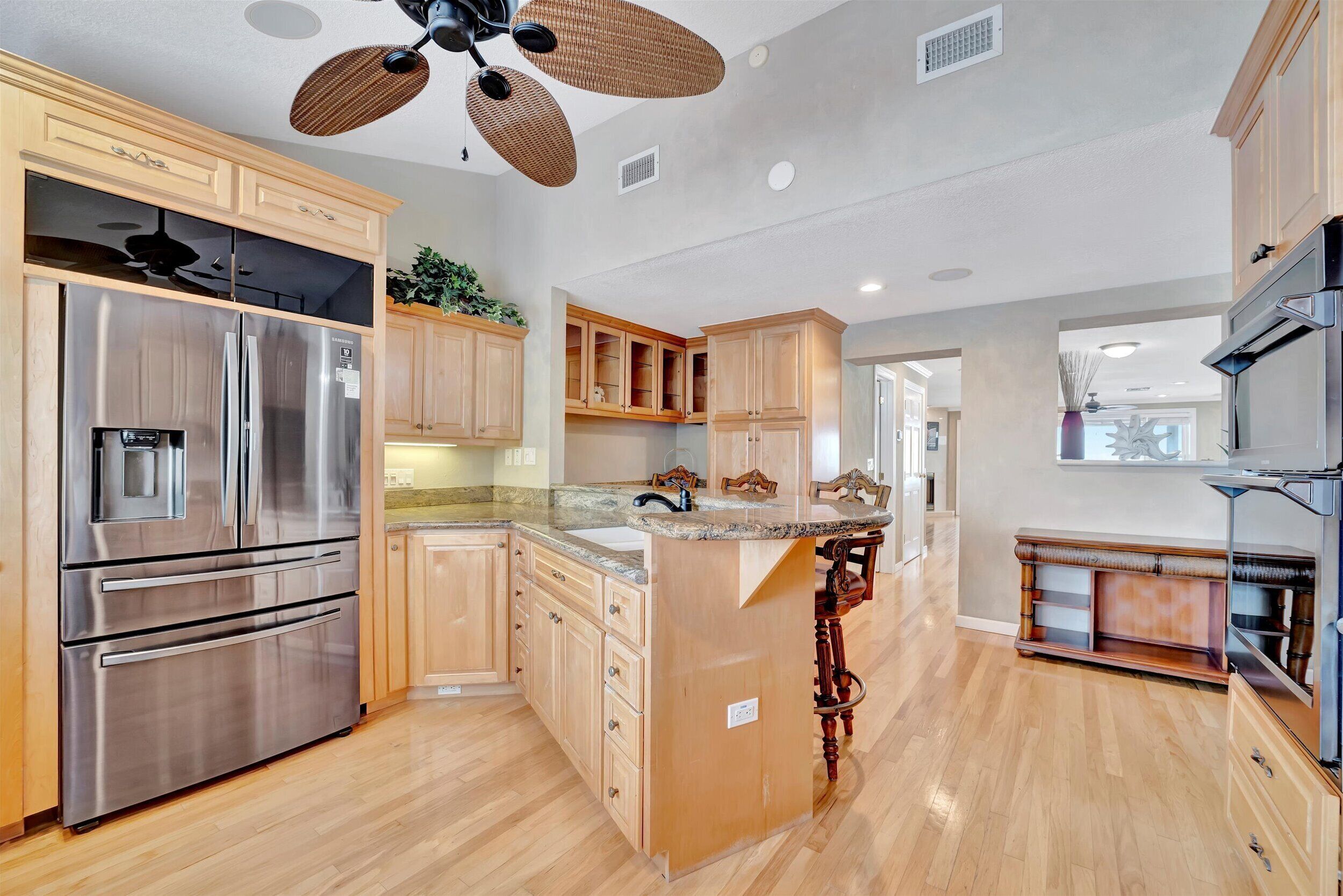 A spacious kitchen with wooden cabinets, stainless steel appliances, and a central island.