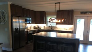 A modern kitchen with a central island, stainless steel appliances, and wooden cabinets. - Paradise palms 3 (Port St. Lucie)