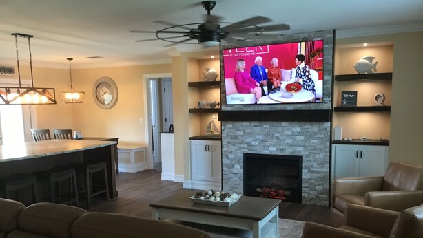 A living room with a fireplace, a television, and a dining area. - Paradise palms 3 (Port St. Lucie)
