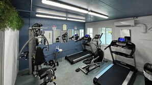 A gym with treadmills, a weight bench, and exercise equipment.