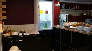 A kitchen with a refrigerator, a sink, and a counter with food items. - Residencial Pinto  (Guarda)
