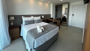 A modern hotel room with a large bed, bedside tables, a desk, and a mirror. - RN STUDIO - APTO 1018 (Maceio)