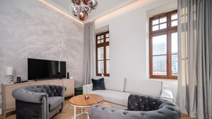 Una sala de estar moderna con un sofá, dos sillones, una mesa de centro, un televisor y una chimenea.