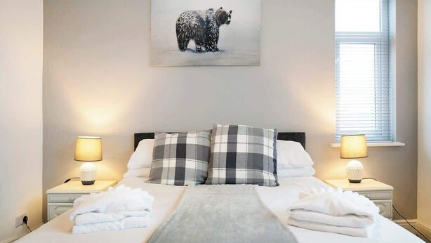 A neatly made bed with a grey blanket, two pillows, and a bear-themed artwork above it. - 3 Bedroom in Haughton Road with Free WiFi (Darlington)