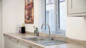 A kitchen with a sink, a window with blinds, and a painting on the wall. - 3 Bedroom in Haughton Road with Free WiFi (Darlington)