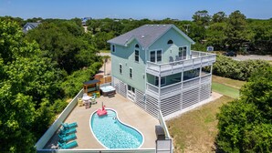 A two-story house with a swimming pool, deck chairs, and a hot tub. - Walk to Beach, Heated Pool, Hot Tub, Dogs OK! (Kitty Hawk)