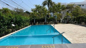A swimming pool with a tiled deck and safety signage.