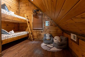 A cozy cabin room with a bunk bed, a ladder, a small window, and two owl-themed chairs. - Nite Owl-Luxury Log Cabin Rental, Outdoor Fire Pit, Fire Place, High Speed Internet, Hot Tub, Pool Table, Open Concept- Nantahala NC (Topton)