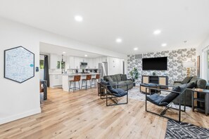A modern living space with a kitchen, dining area, and seating area. - The Getaway House | St Charles 4BR Sleeps 11 Game Room | Hot Tub | Mercer Stays (Saint Charles)