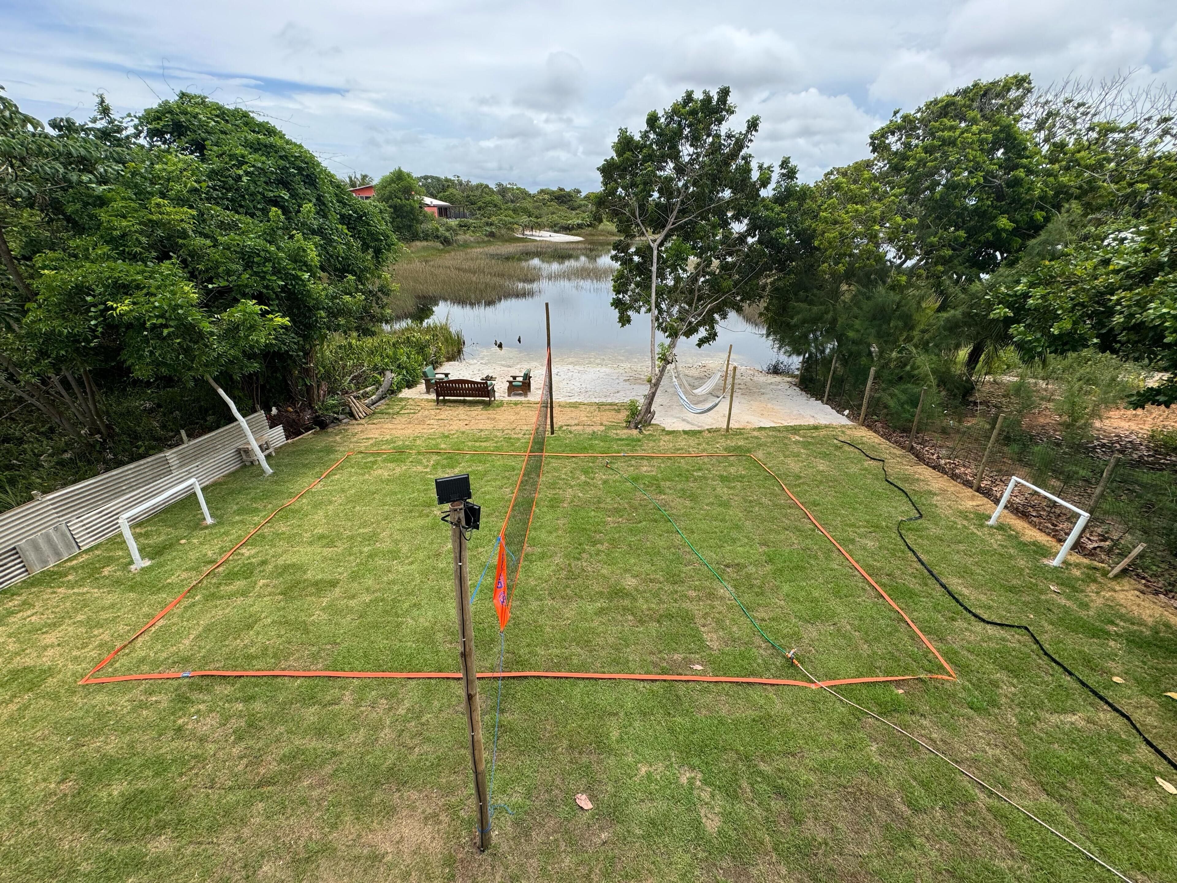 Un espace verdoyant avec un hamac, un banc et une vue sur un lac.