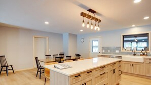 A modern kitchen with a central island, wooden cabinets, and a built-in oven. - Snowmobile & Enjoy Eagle River! ‘Southside Lodge’ (Eagle River)