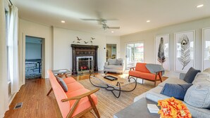 A spacious living room with a fireplace, a ceiling fan, and a large window. - Riverfront Gem w/ Fire Pit in Eden (Eden)