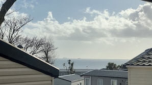 Un puerto deportivo con varias lanchas amarradas, cielo despejado con algunas nubes y vista al océano.