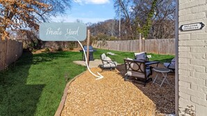 A backyard with a patio area, outdoor furniture, and a 'Private Yard' sign.