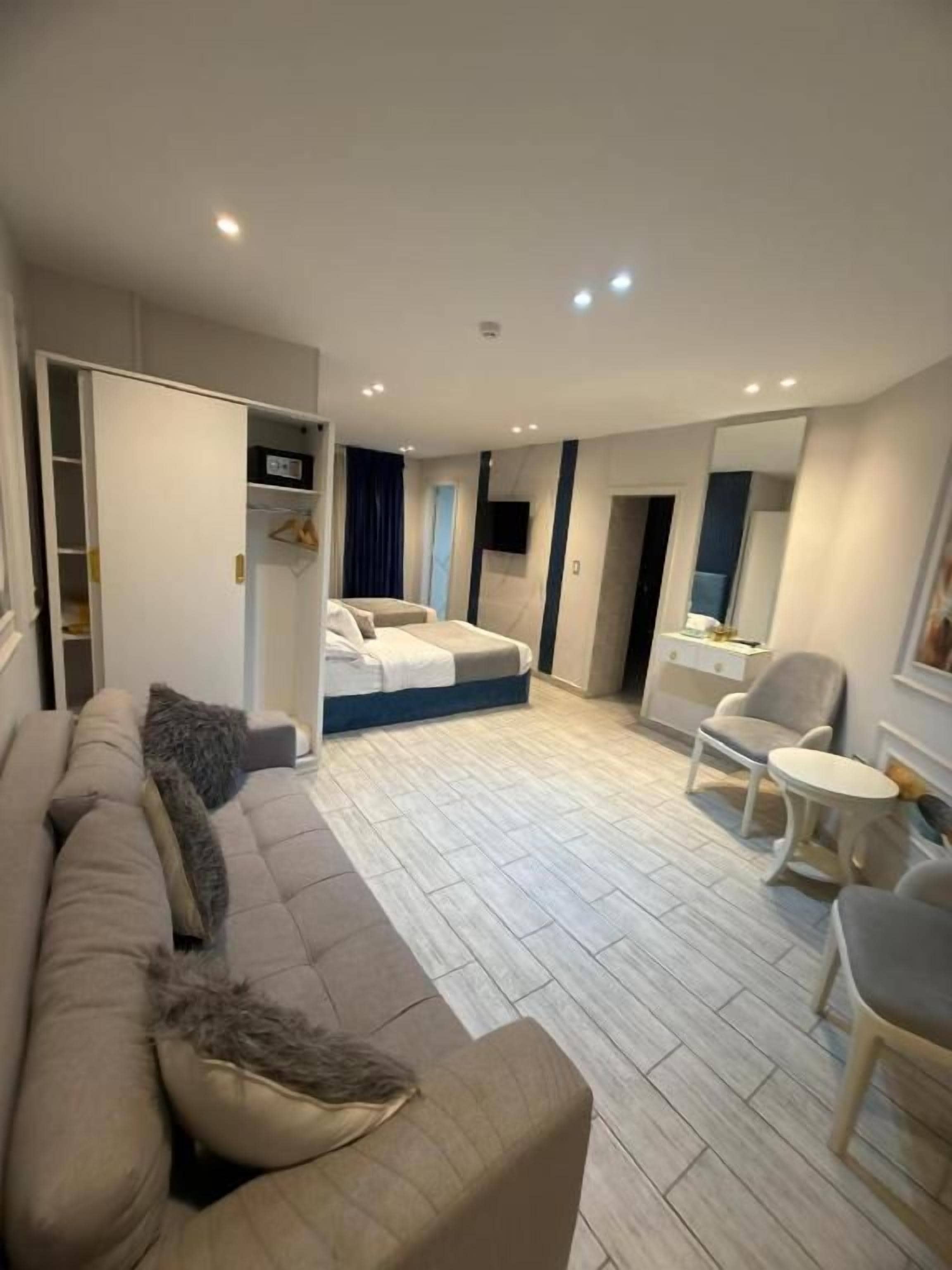 A modern hotel room with a sofa, a bed, a small table, and a chair.