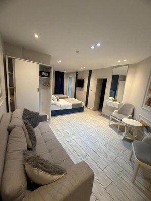 A modern hotel room with a sofa, a bed, a small table, and a chair. - lotus Altahrir hotel (Cairo)