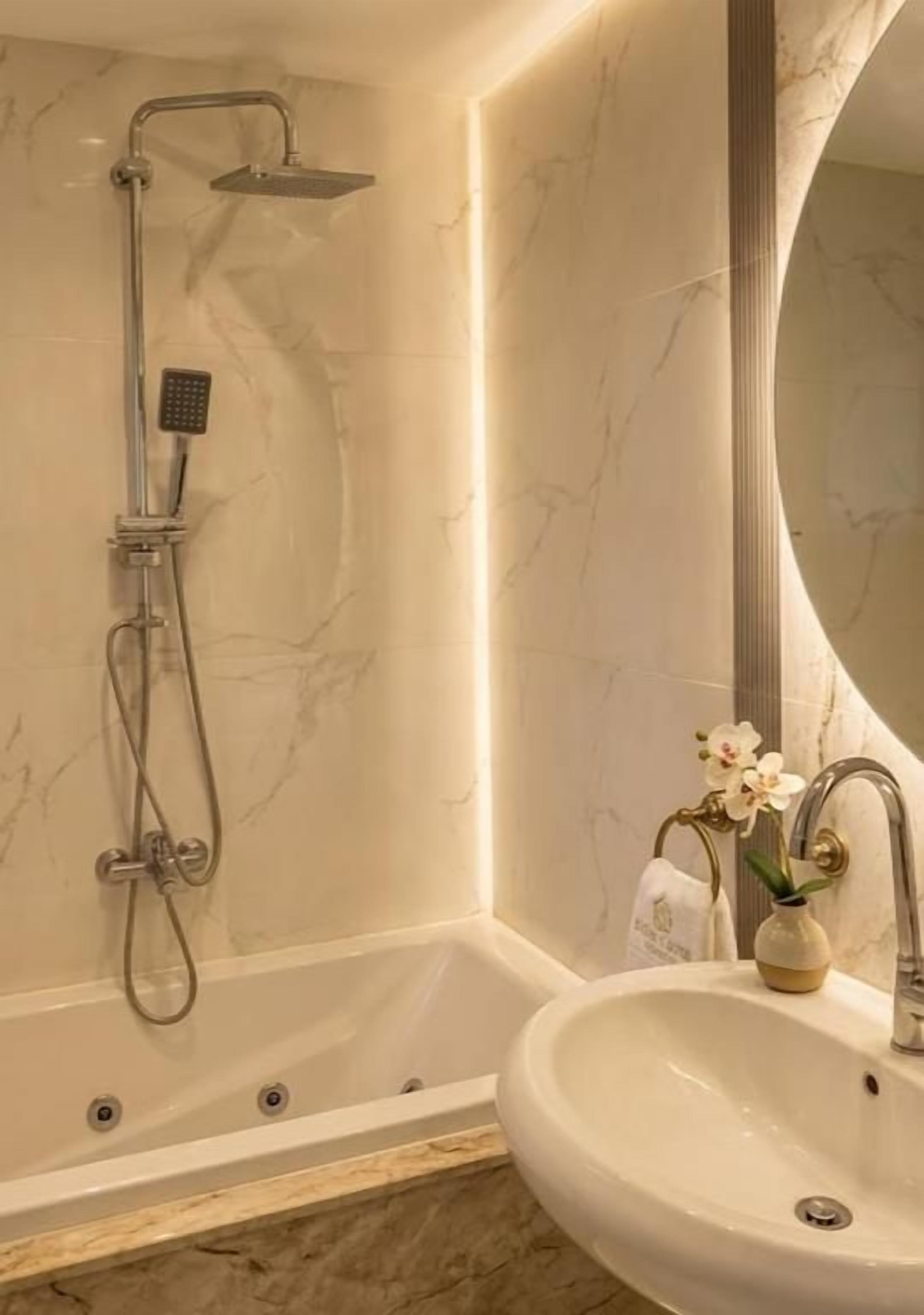 A bathroom with a bathtub, a shower, and a sink.