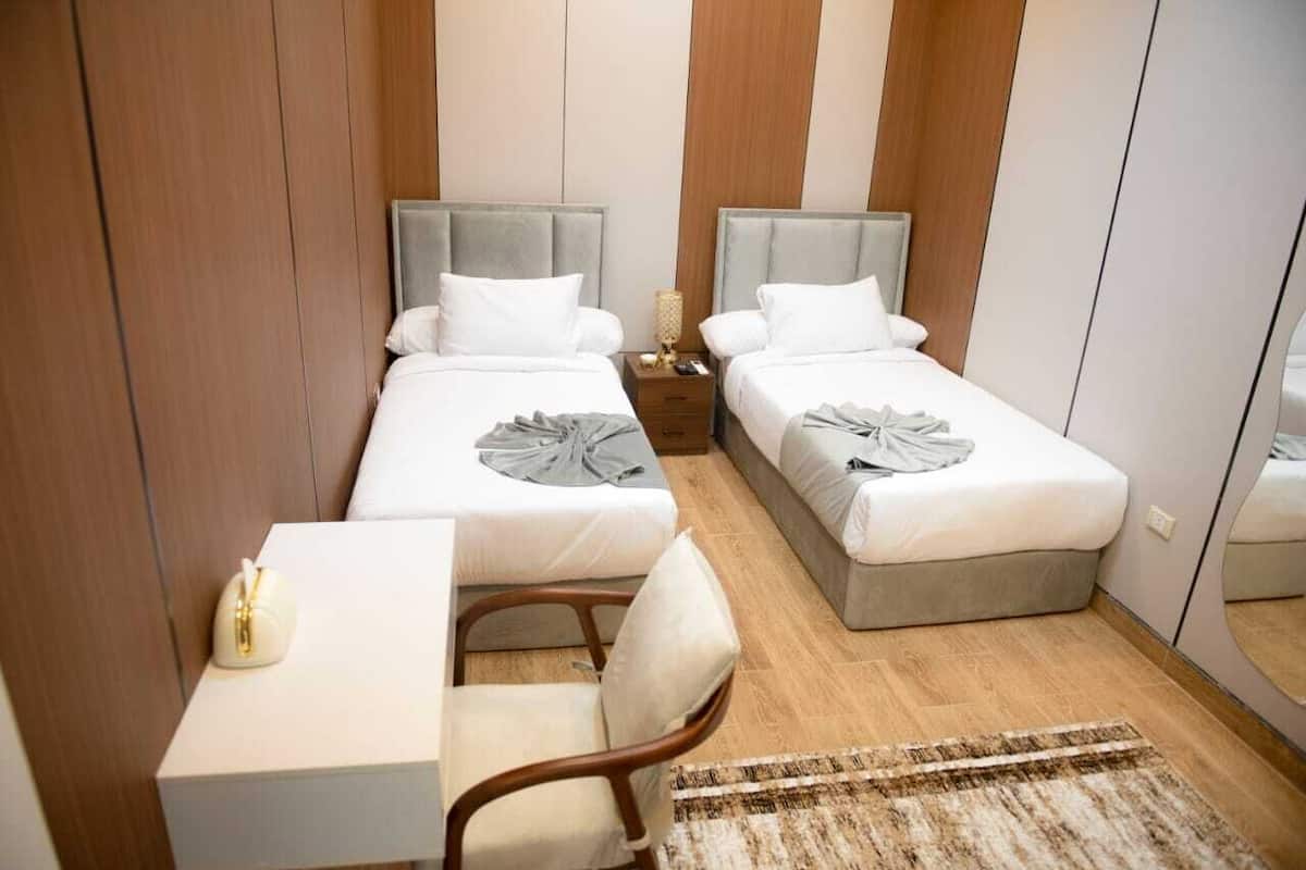 Una habitación de hotel con dos camas, un escritorio y una silla.