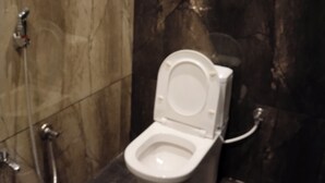 A bathroom with a toilet, a bidet, and a shower. - LIMRA FARM HOUSE  (Anaimalai)