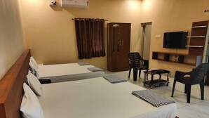 A hotel room with two beds, a TV, a wardrobe, and a small table. - LIMRA FARM HOUSE  (Anaimalai)