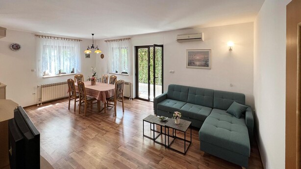 Una sala de estar con un sofá, una mesa de comedor con sillas y una pequeña mesa de centro.
