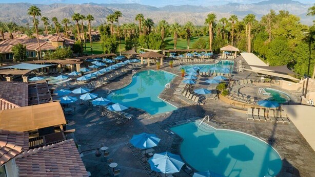A resort with multiple swimming pools, sun loungers, and umbrellas.